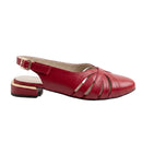 A red leather slingback sandal with cutout straps, a low block heel with a gold accent, and an adjustable ankle strap, shown on a white reflective studio background.