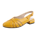 A single women's yellow slingback sandal with a low block heel, cutout straps, and a buckle strap, shown on a reflective white surface.
